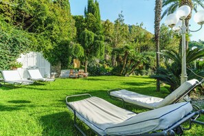 Un jardín con dos sillones de descanso, una mesa y un farol.