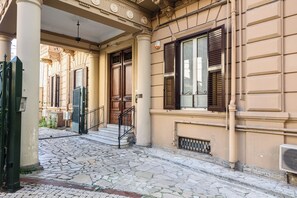A building with a stone-paved entrance, wooden doors, and a metal gate. - Via del Parco Margherita 24 (Naples)