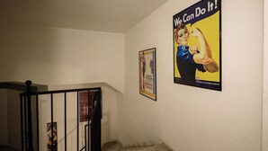 En trappe med gelænder i sort og plakater på væggene.