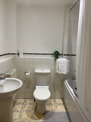 A bathroom with a toilet, sink, and bathtub. - Modern 2BR House Sleeps 6 Parking, Wi-Fi & Self Check-In Near Bluewater & London (Greenhithe)