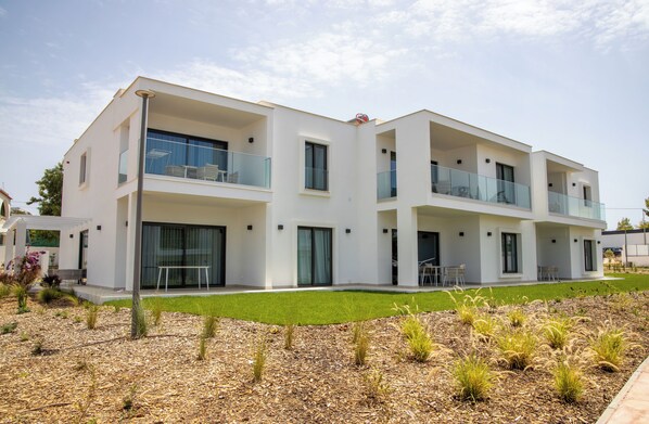 A modern two-story residential building with balconies, large windows, and a well-maintained lawn. - Primelife Carvoeiro (Carvoeiro)