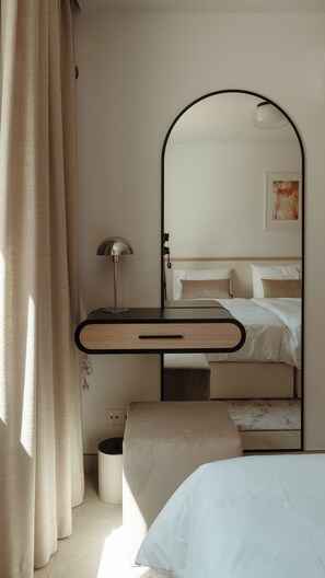 A bedroom with a bed, a bedside table with a lamp, a mirror, and a small bedside table. - Prime Resorts - PrimeLife Carvoeiro (Carvoeiro)