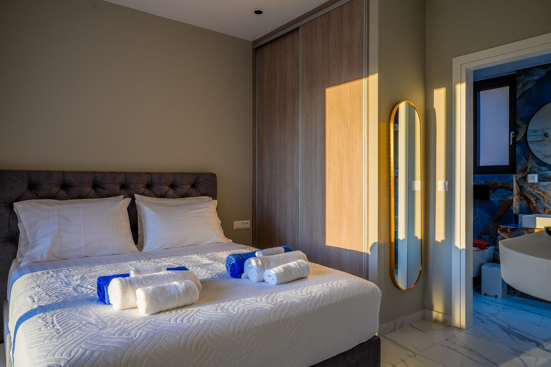 Une chambre d’hôtel avec un grand lit, un miroir et une vue sur la salle de bain.