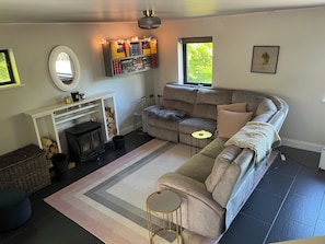 Ein gemütliches Wohnzimmer mit Kamin, einer Couch, einem Teppich und einem Bücherregal.