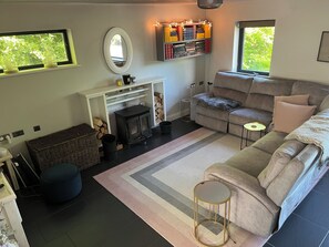 Ein gemütliches Wohnzimmer mit Kamin, einer Couch, einem Couchtisch und einem Bücherregal.