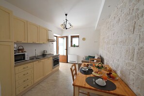 Eine Küche mit Holzausstattung, einer Mikrowelle und einem Essbereich mit gedecktem Tisch zum Frühstück.