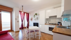 Eine moderne Küche mit weißen Schränken, einer Holzausziehtafel und einem Essbereich mit Tisch und Stühlen.