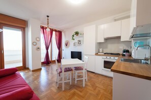 Eine moderne Küche mit weißen Schränken, einer Holzausziehtafel und einem Essbereich mit Tisch und Stühlen.