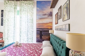 A hotel room with a bed, a chair, a lamp, and artwork on the wall. - Spacious 80 sqm apartment with a balcony, comfortably accommodating up to 4 people, located on the third floor of a building with an elevator. The property is located in the charming Centro neighborhood, in the heart of Livorno's nightlife, just steps fr (Livorno)