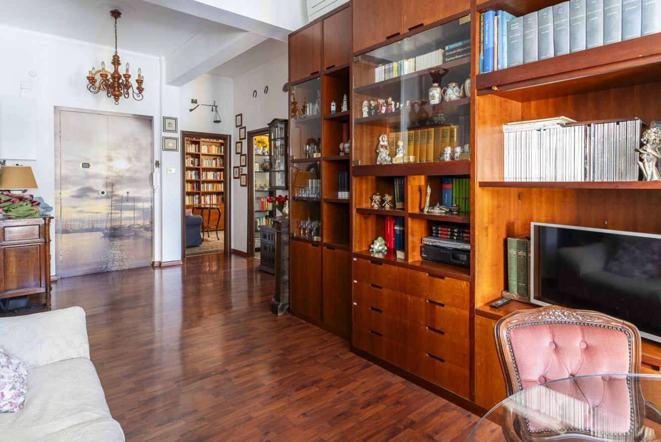 A spacious living room with a large wooden bookshelf, a television, and a comfortable seating area.