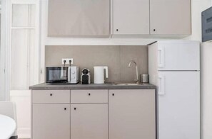 Una cocina compacta equipada con microondas, tostadora y pileta.