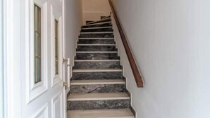 A staircase with marble steps and a wooden handrail, leading to a door with glass panels. - Charming Couples' Apartment in Zakynthos Town (Zakinthos)