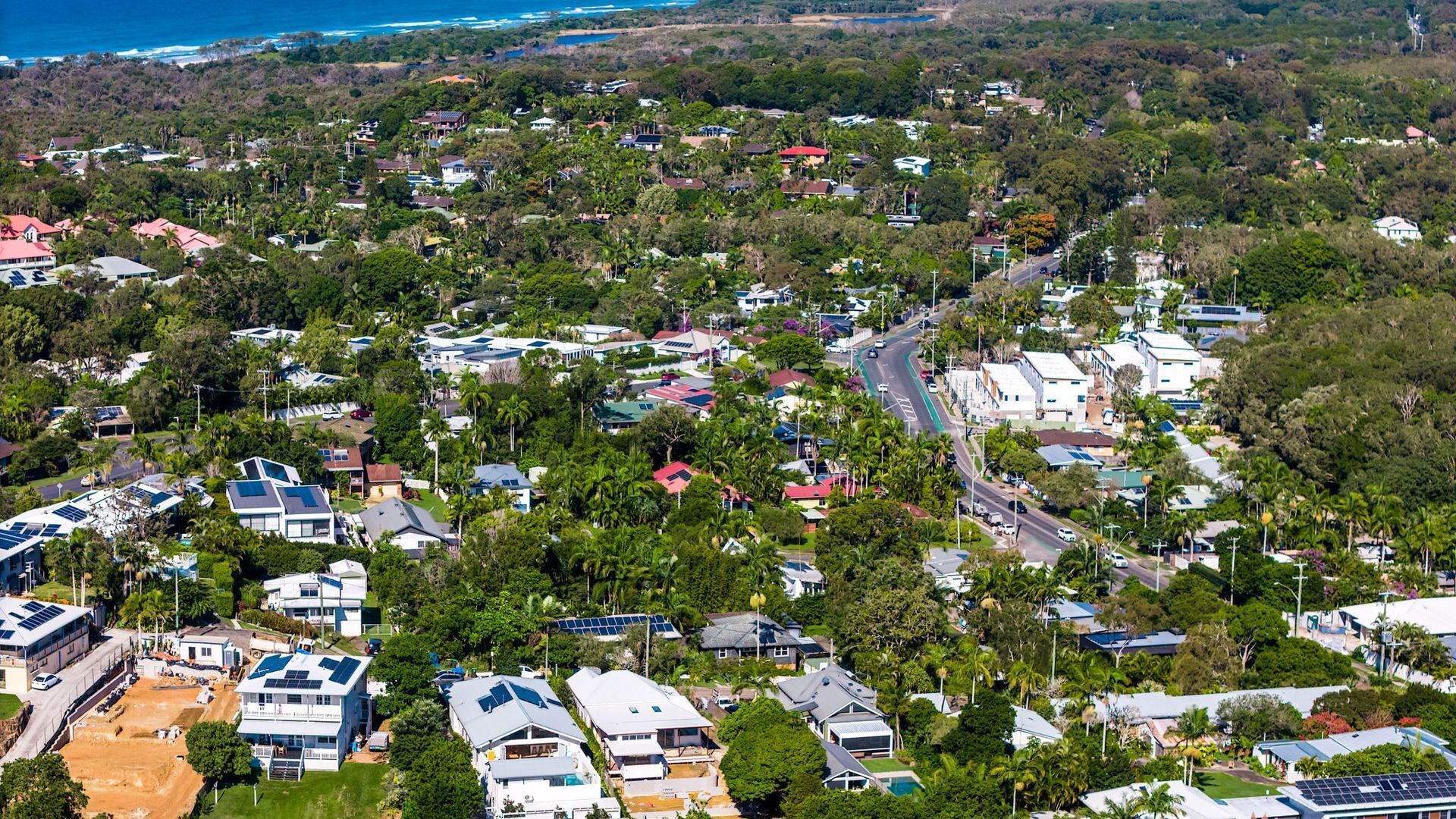 An aerial view of a residential area with houses, roads, and greenery.