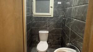 A small bathroom with a toilet, a sink, and a mirror on the wall.