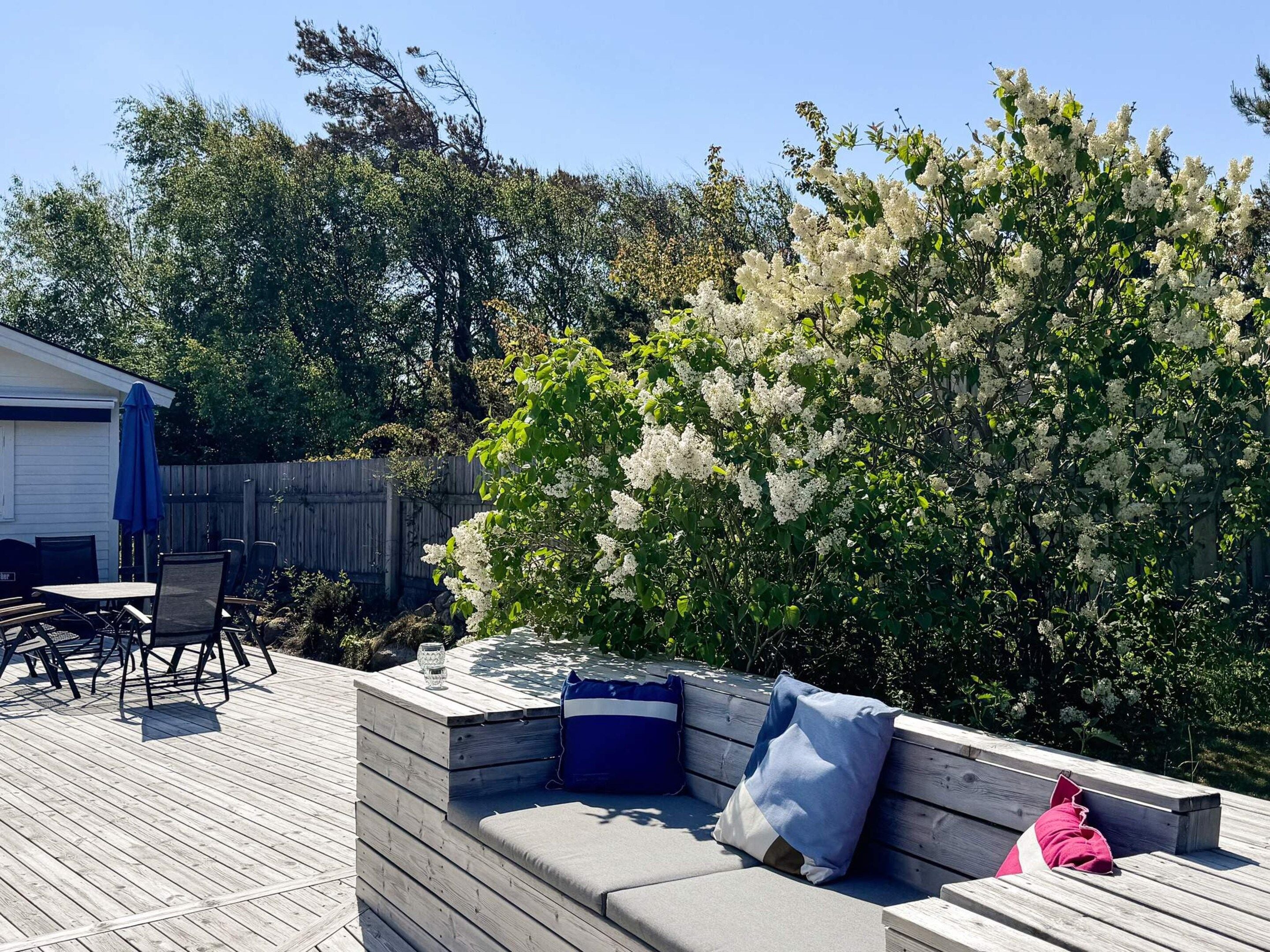 An outdoor patio with a built-in seating area, a table, and chairs.