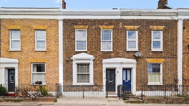 A row of terraced houses with brick facades, white window frames, and black metal fences. - Modern 5 bed New Cross Greenwich House (London)
