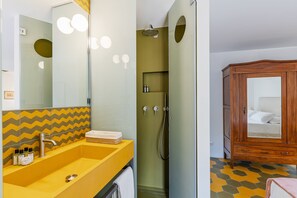 A bathroom with a yellow sink, a shower, and a wooden cabinet with a mirror. - Luxury Loft in Navona - Anima (Rome)