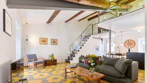 Un salon moderne avec un canapé, une table basse et un escalier.