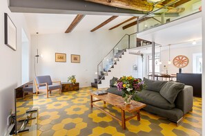 Una sala de estar moderna con sofá, una mesa de centro y una escalera.