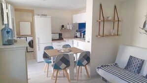 A compact living space with a dining area, kitchenette, and a sofa. - Gîte Nath & Steph 5 classified 3*** in Cayeux sur Mer - Baie de Somme (Cayeux-sur-Mer)