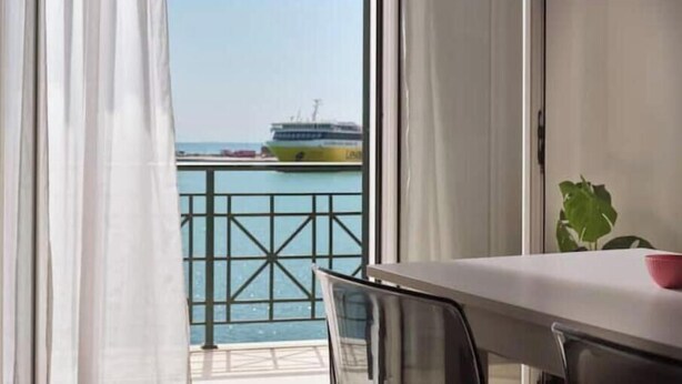 Een balkon met uitzicht op een cruiseschip, een tafel en een stoel.