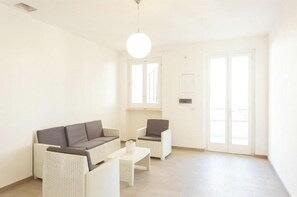 A modern living room with a sofa, two armchairs, a coffee table, and a large window with a view. - Sole Holiday Home - Holiday home with terrace near the sea in Porto Cesareo (Porto Cesareo)