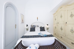 Ein Schlafzimmer mit Bett, Nachttischen, einem Kleiderschrank und einer Tür.