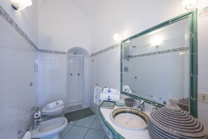 Un bagno con vasca, lavandino, WC e doccia.