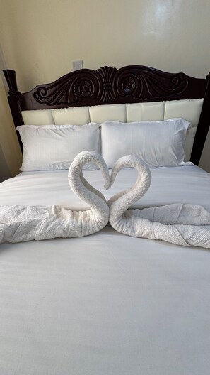 Ein Bett mit einer herzförmigen Handtuchgestaltung.