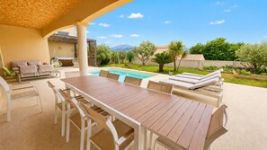 Eine Außenpatio mit Pool, Liegestühlen und Essbereich.