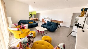 Ein modernes Wohnzimmer mit Sofa, Sessel und Couchtisch.