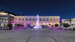 A square with a central fountain and a building with arched windows. - Poet's Square Modern Residence 2 (Zakinthos)