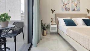 A modern bedroom with a bed, bedside table, and a window with curtains. - Poet's Square Modern Residence 2 (Zakinthos)