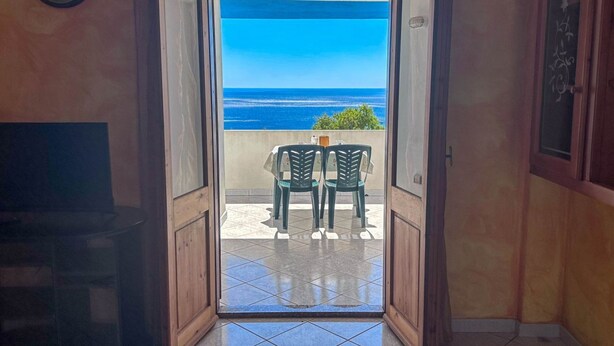 Un vano abierto que da a un balcón con vistas al océano.