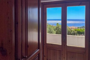 A wooden door with a view of the ocean and greenery. - Appartamento Tuttavista (Cala Gonone)