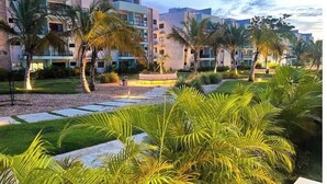 Cortile di un hotel con palme, un'area circolare al centro e edifici moderni sullo sfondo.