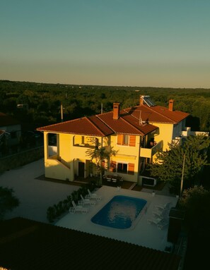 A two-story house with a swimming pool and outdoor seating. - Tuscany Apartment (Vodnjan)