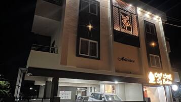 A multi-story building with a car parked in front.