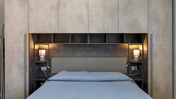 A bed with a headboard, bedside lamps, and a wall unit with shelves. - Bed and Breakfast 'Villa Giusy' with Private Garden (Verdellino)