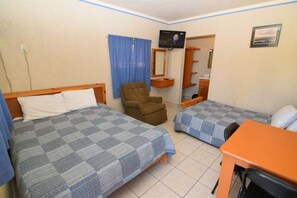 A room with two beds, a chair, a TV, and a desk. - San Felipe Studio One (San Felipe)