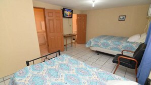 Une chambre avec deux lits, une télévision, un bureau et une chaise.