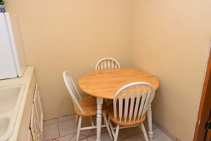 A small dining area with a round wooden table and two white chairs. - San Felipe Studio Fout (San Felipe)