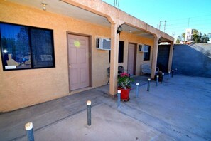 A building with a beige exterior, a door, and a window. There are air conditioning units on the wall and a potted plant with flowers. - San Felipe Studio Five (San Felipe)