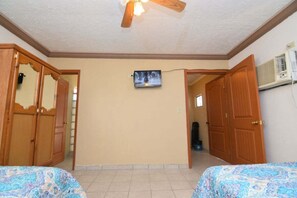 A room with two beds, a ceiling fan, a television on the wall, and wooden doors. - San Felipe Studio Five (San Felipe)