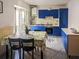 Una cucina compatta con mobili blu, un piano cottura a gas e un forno integrato.
