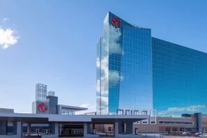 A modern building with a glass facade and a red logo on the side.