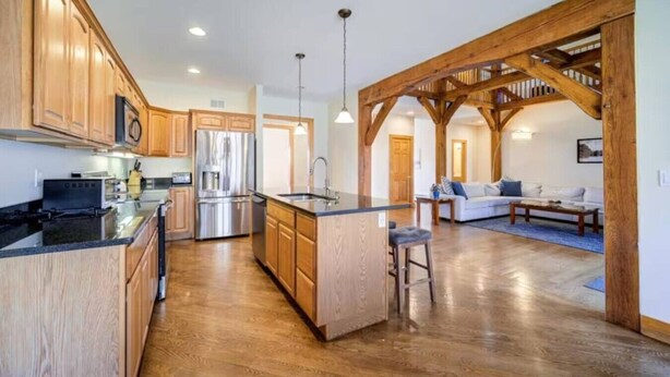 Una cocina amplia con armarios de madera, una isla central y un refrigerador moderno.