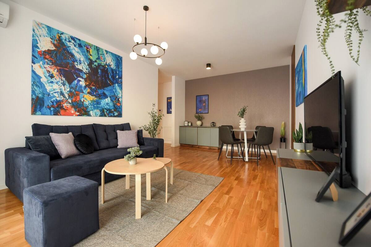 A modern living room with a sofa, coffee table, and dining area.