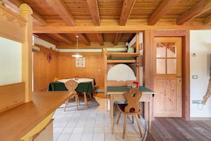 Ein Holzinterieur mit Esstisch, Stühlen und einem Etagenbett.