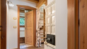 A wooden interior with a fireplace, a wooden door, and a curtain.